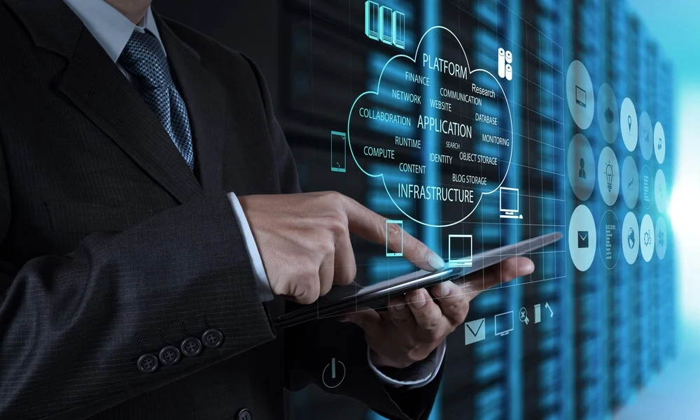 A man in a black suit and silver tie holding an iPad showing the evolution of Digital Marketing.