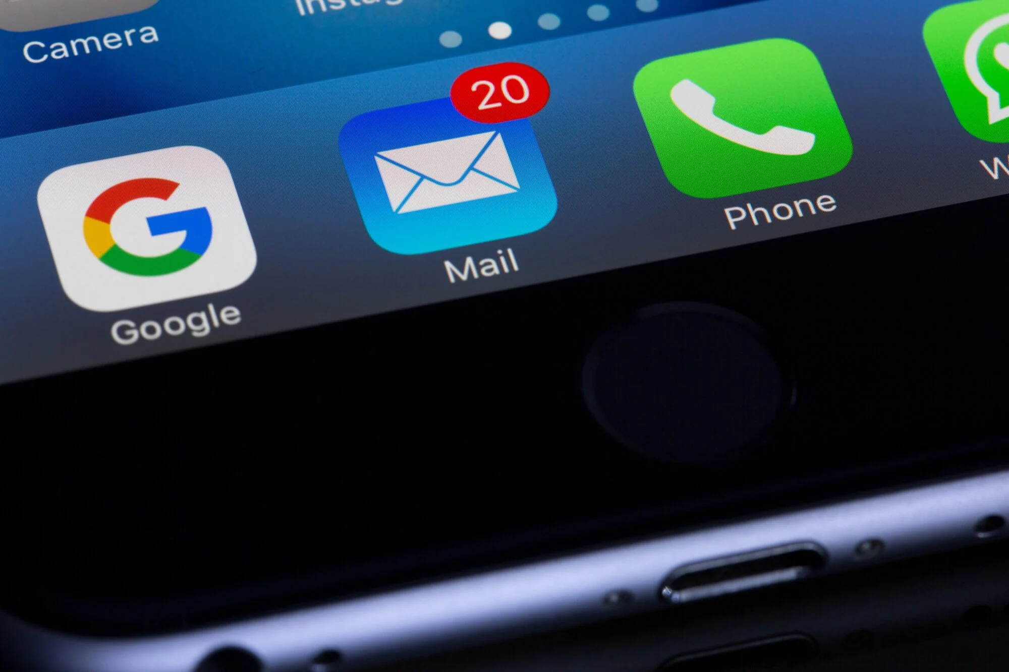 A display of an iPhone, featuring several applications including the mail which has 20 unopened emails. 