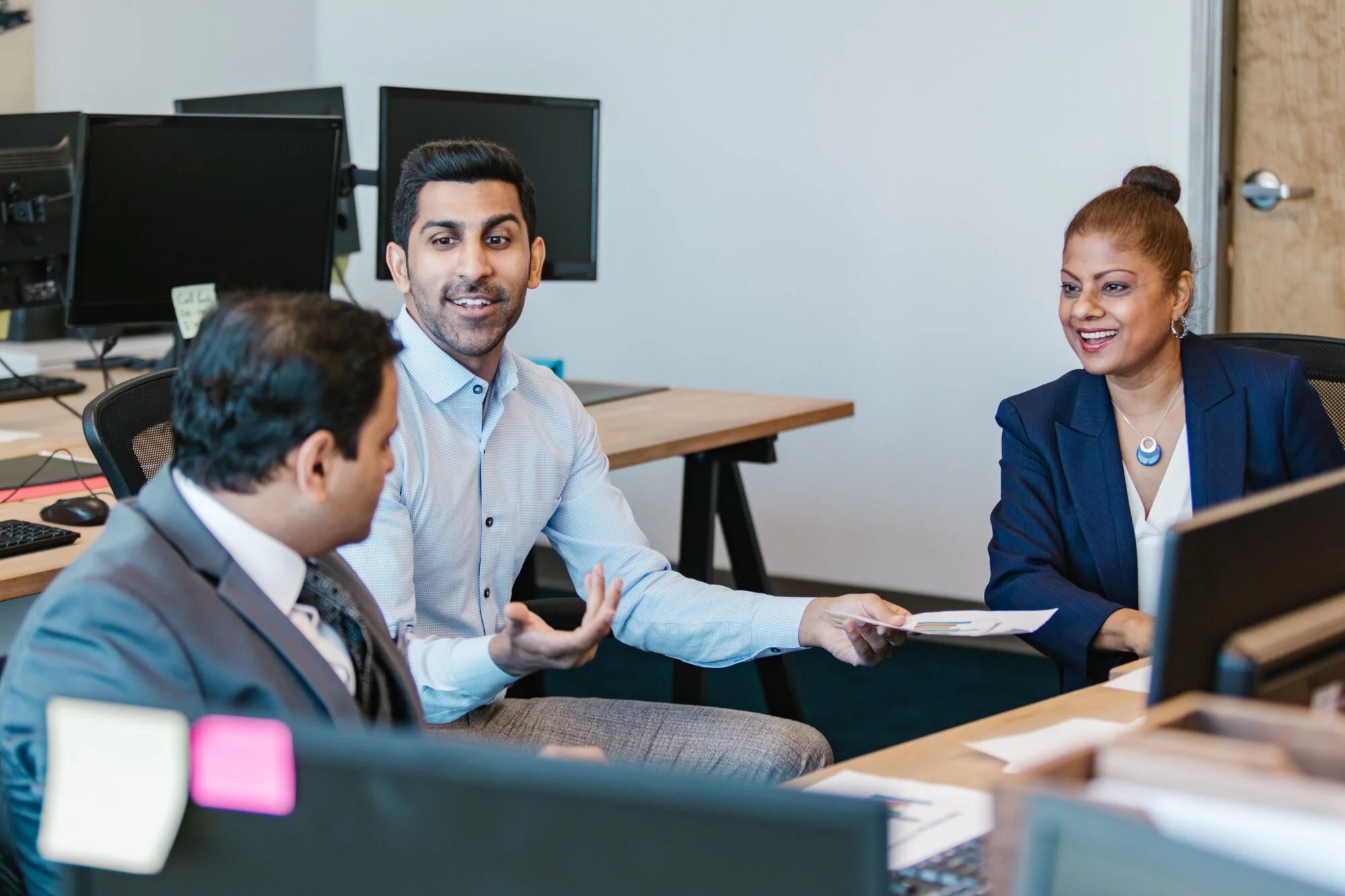 Three individuals in a meeting.