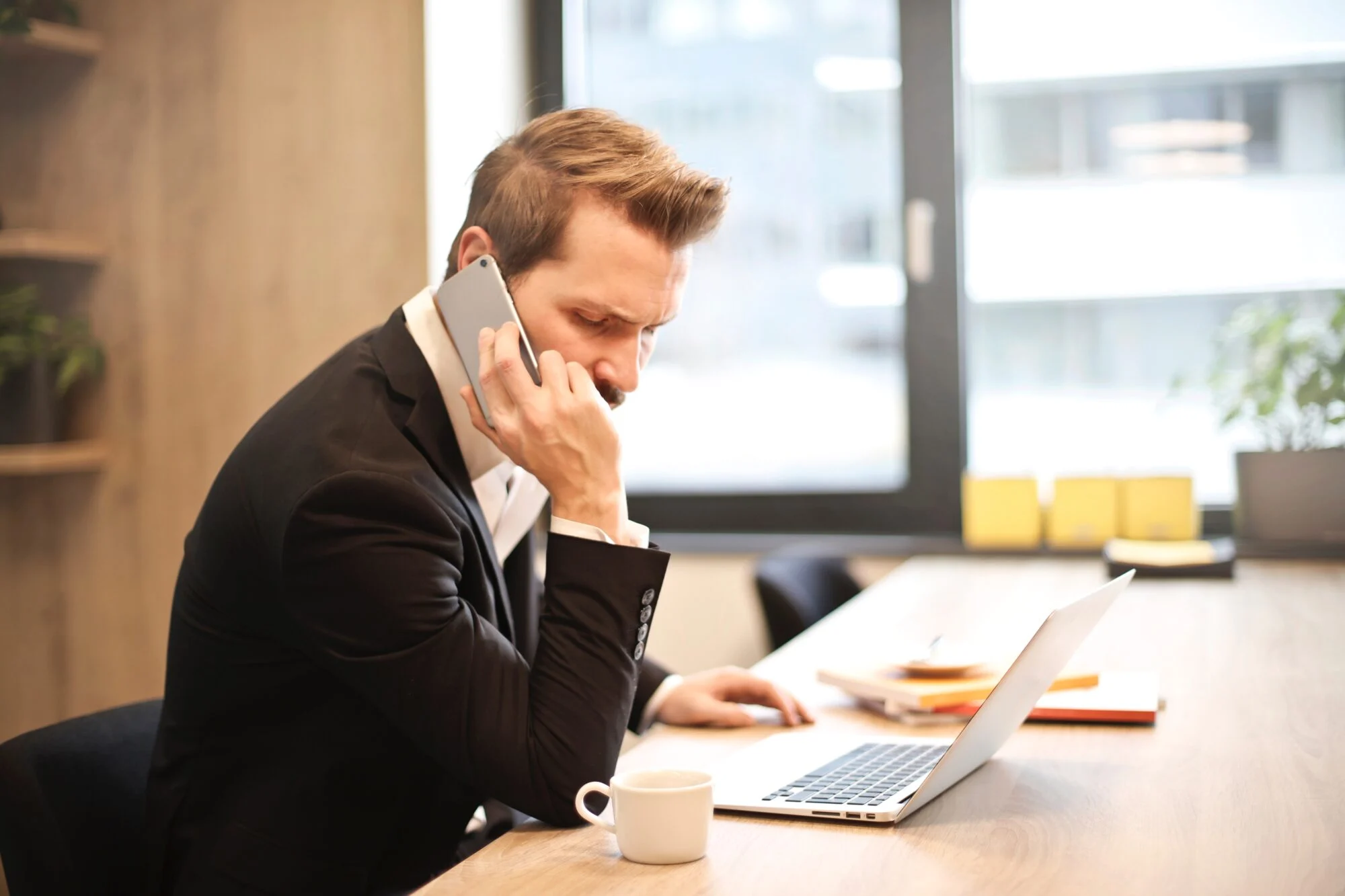 A person in an office leaving a voicemail. 