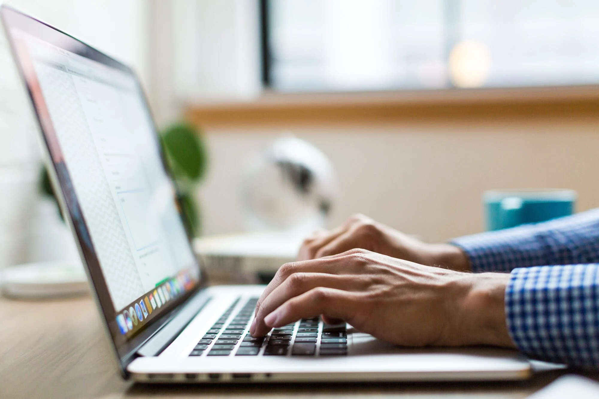 A person typing on a Macbook, 