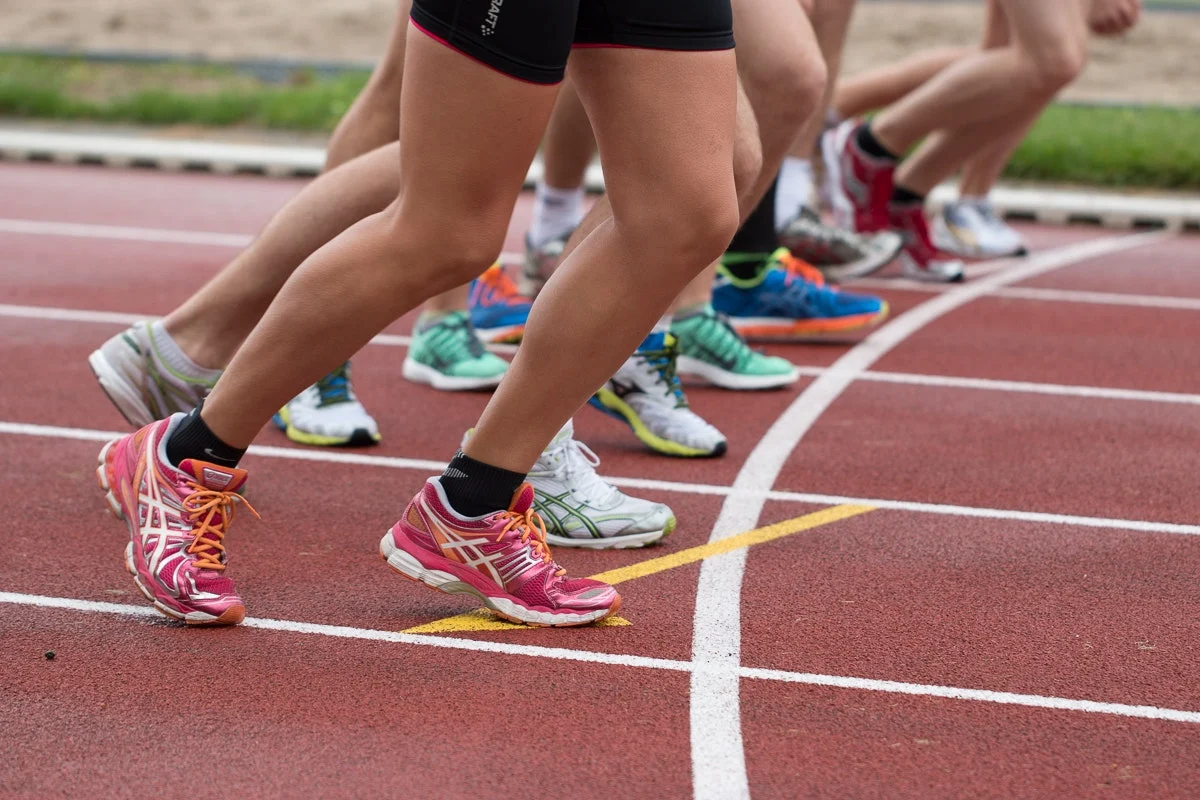 Several runners on the start of a track ready to commence the race.