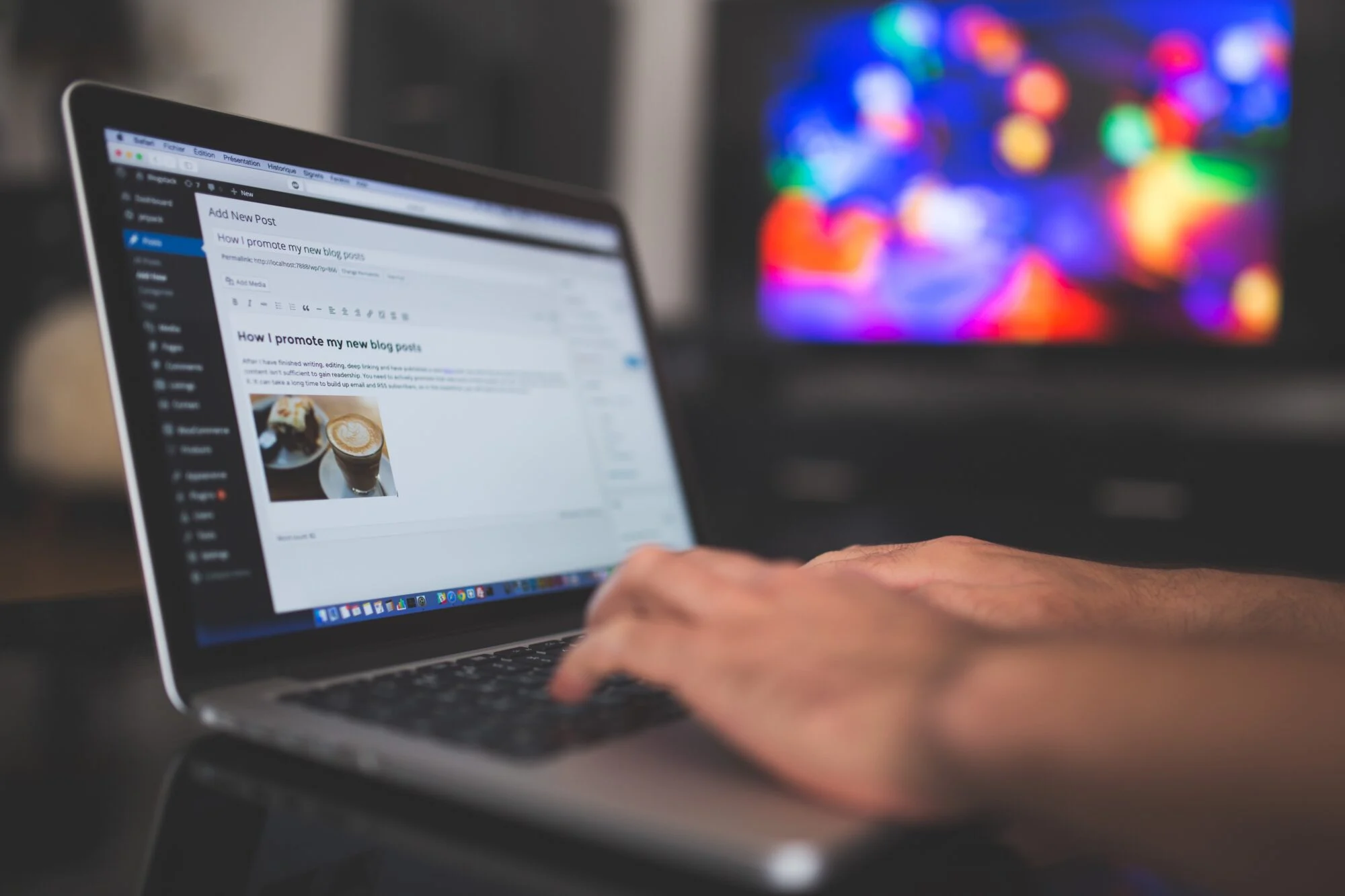 A person working on his laptop with WordPress open as they are creating a blog post. 