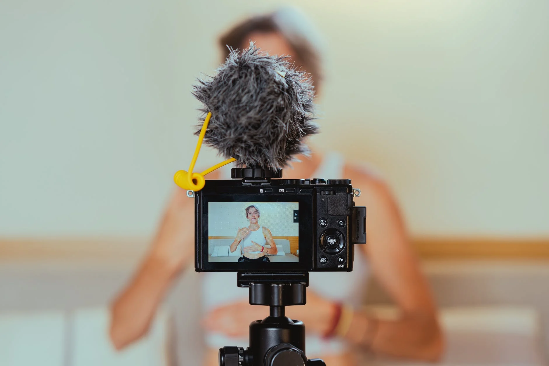 A woman standing behind a recording camera 