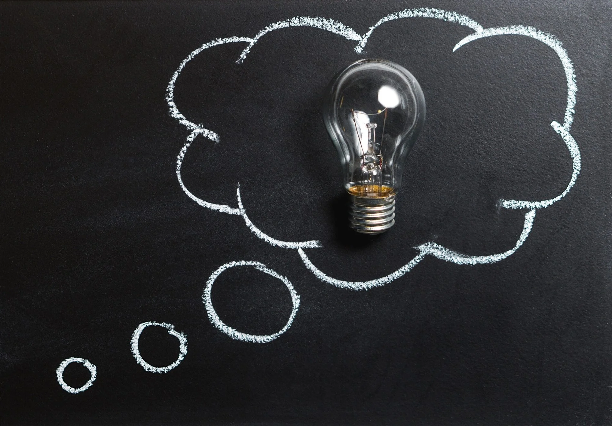 A bulb displayed up on a blackboard. 