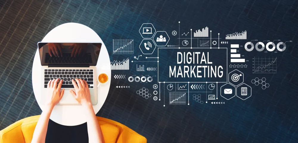 Photograph of a dark blue background with a woman on her laptop with the words "digital marketing" written beside her