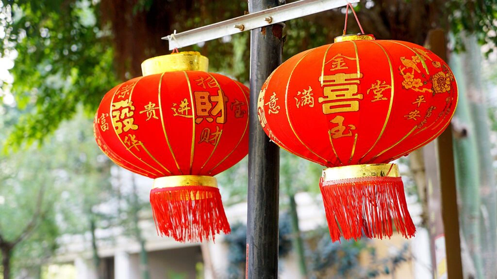 Red Chinese lanterns with gold characters hanging outdoors for Chinese New Year Red Chinese lanterns with gold characters hanging outdoors for Chinese New Year