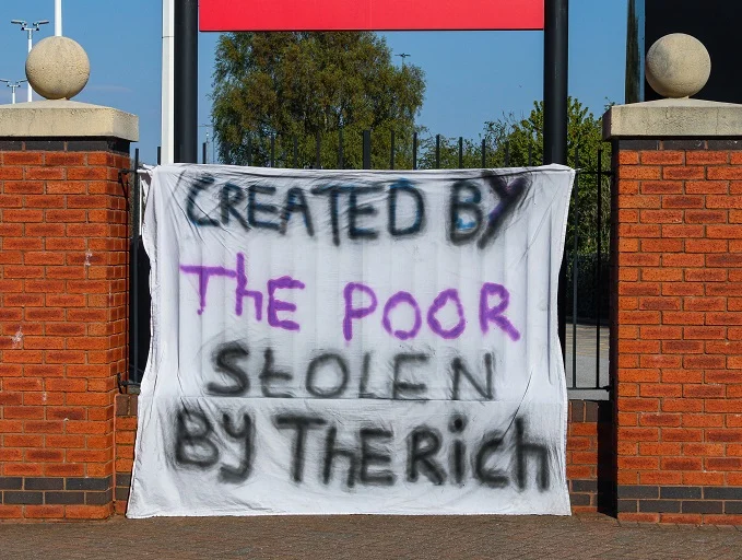 A banner outside of Old Trafford as the fans are showing their displeasure for the Super League, as the banner says; "Created by the poor stolen by the rich".