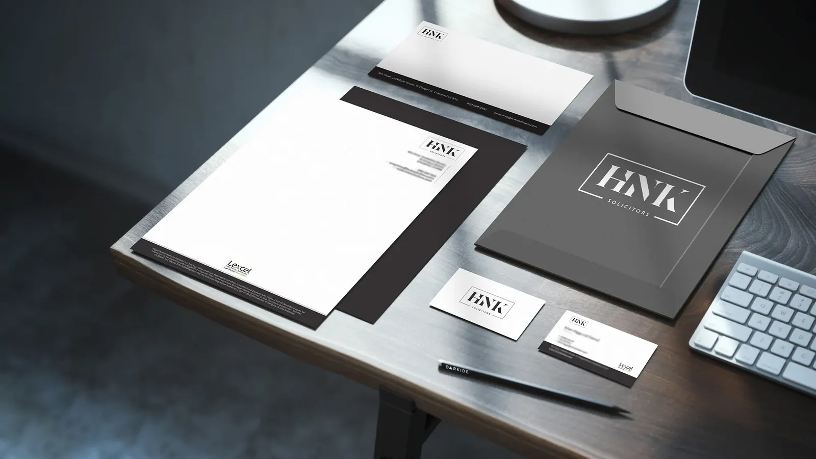HNK Solicitors brand identity: letterhead, folder and business cards.