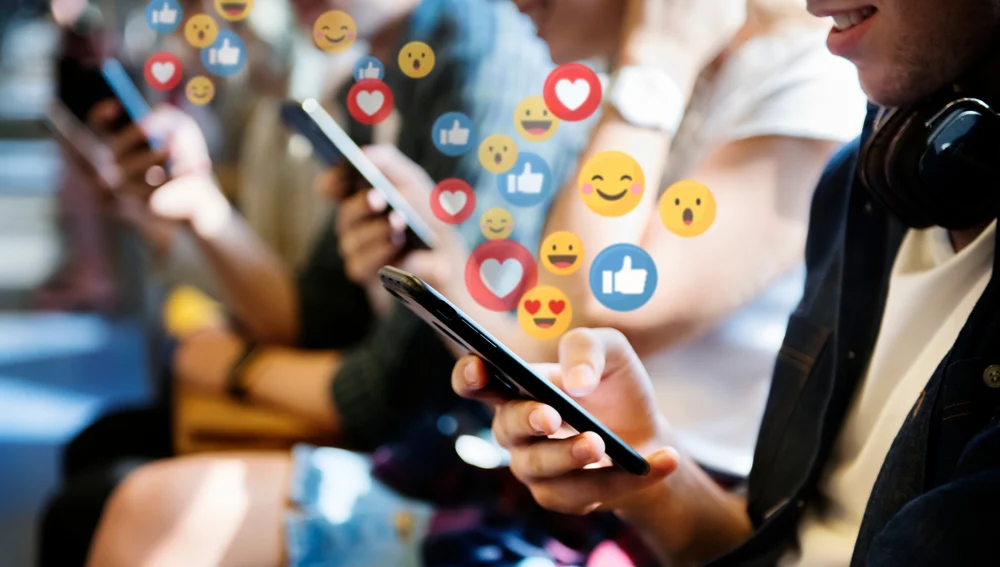A variety of people on their mobile phones using social media apps and liking, sharing and commenting on various posts.
