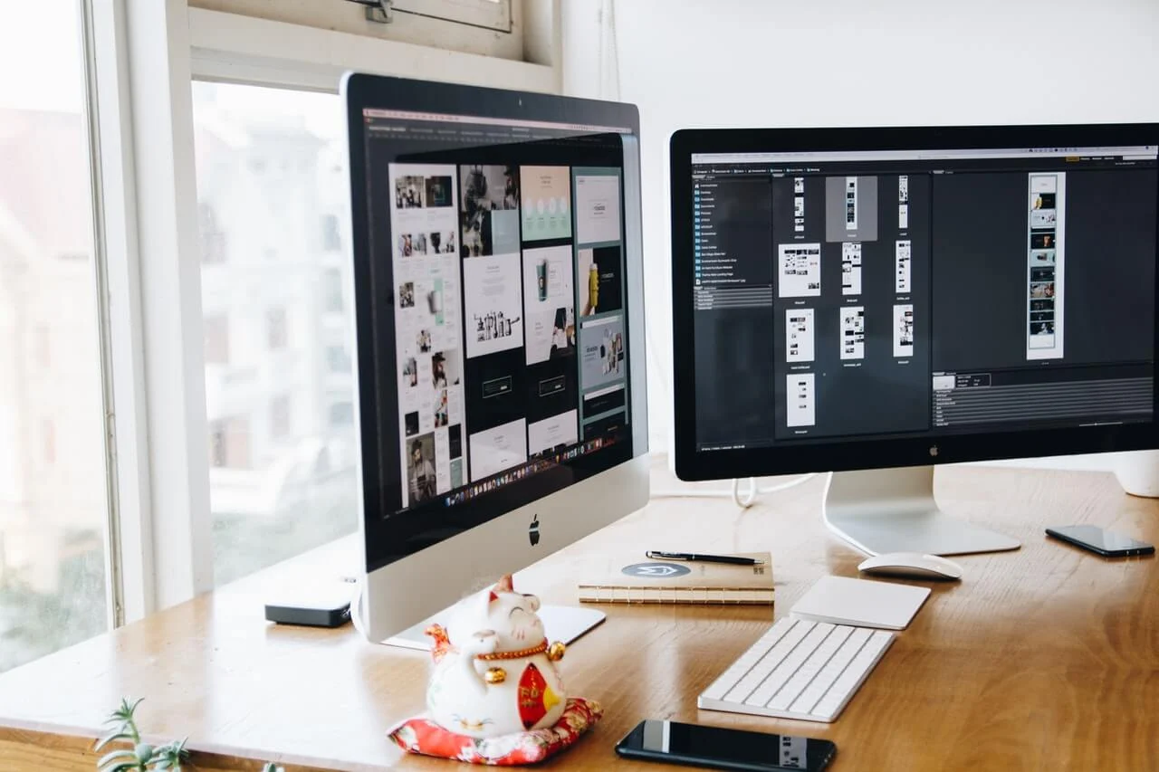 A wooden desk with an Apple computer with Adobe Photoshop open showing how to increase the resolution of an image. 