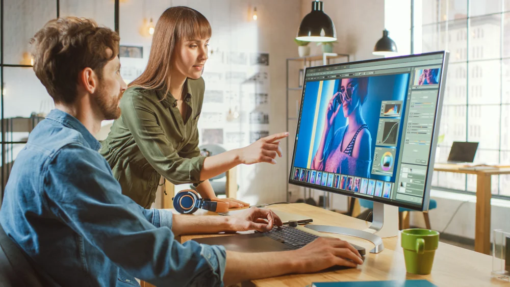 Two colleagues working on Photoshop editing an image.