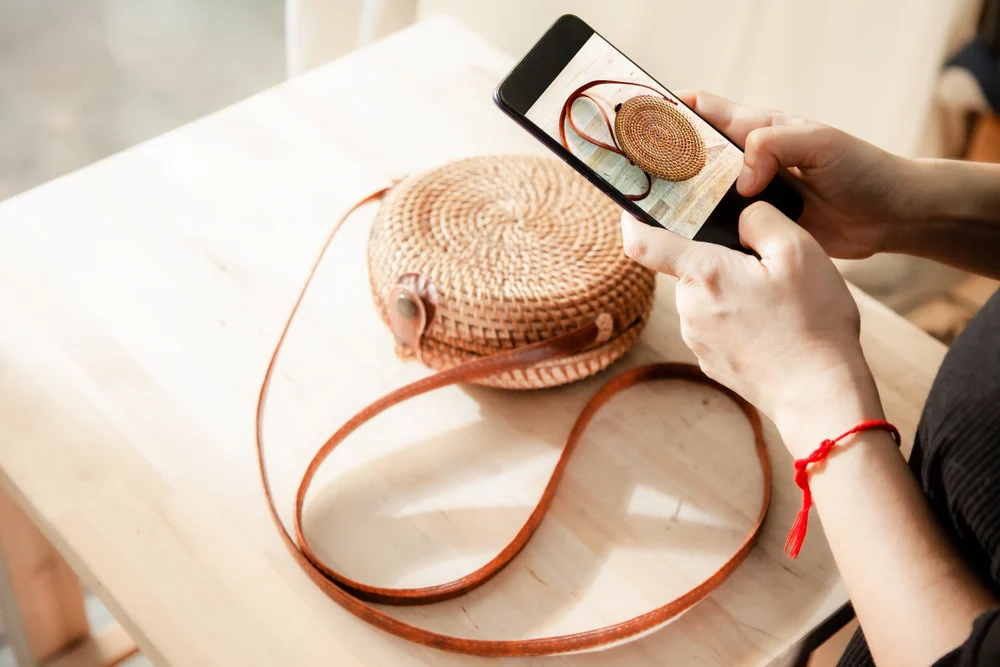 A person taking a photo of their bag on their iPhone. 