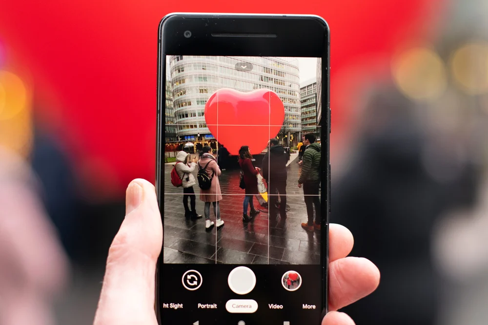 A person taking a photo on their iPhone, using the rule of thirds grid on the camera to take a picture. 