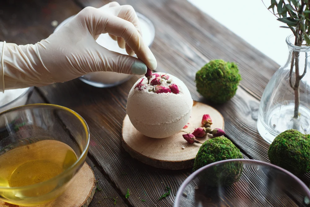 Close up of gloved hand making bath bomb with environmentally friendly ingredients