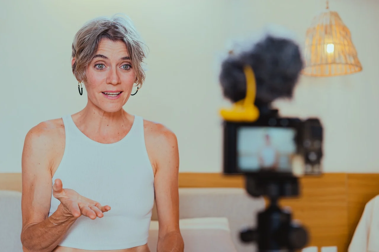 A fitness influencer recording a video to motivate her followers with a new fitness regime. 