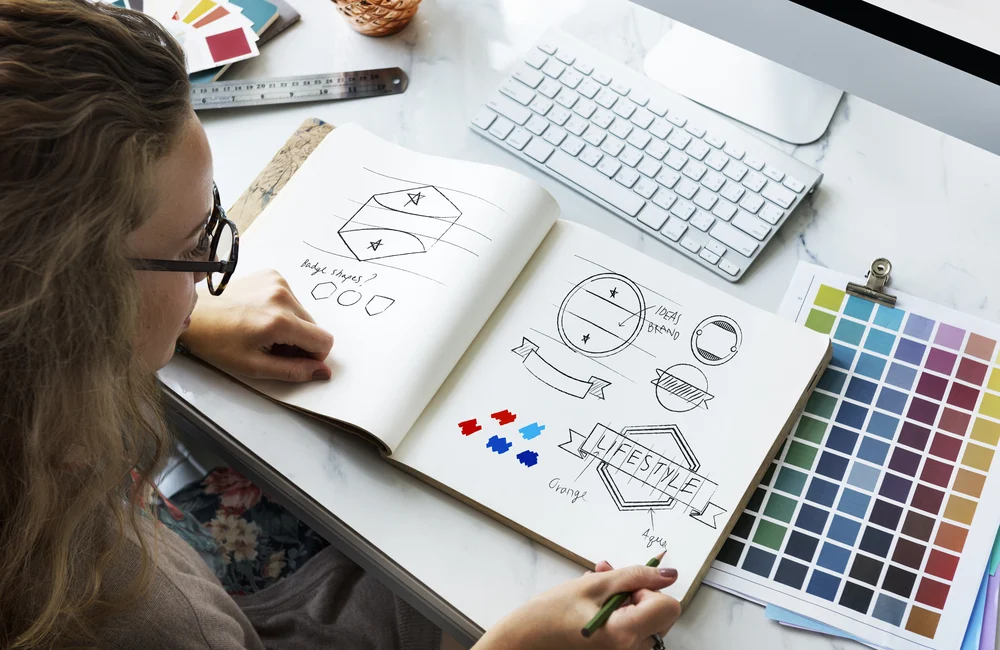 A person drawing a logo for a design portfolio. 