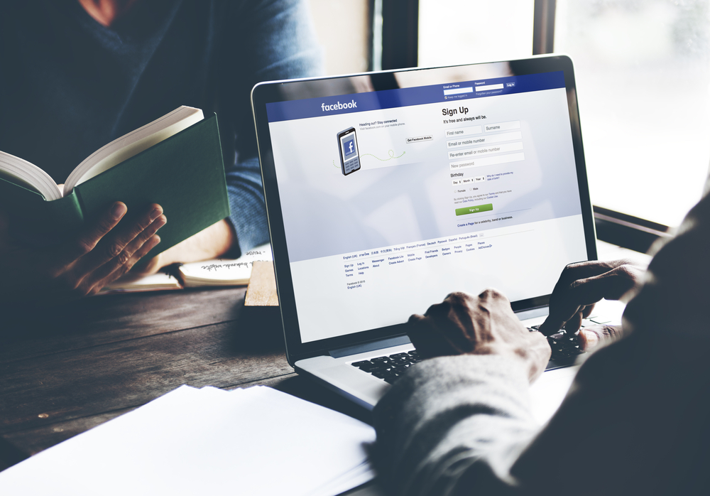 A social media marketer logging into Facebook to show how to schedule a facebook post.