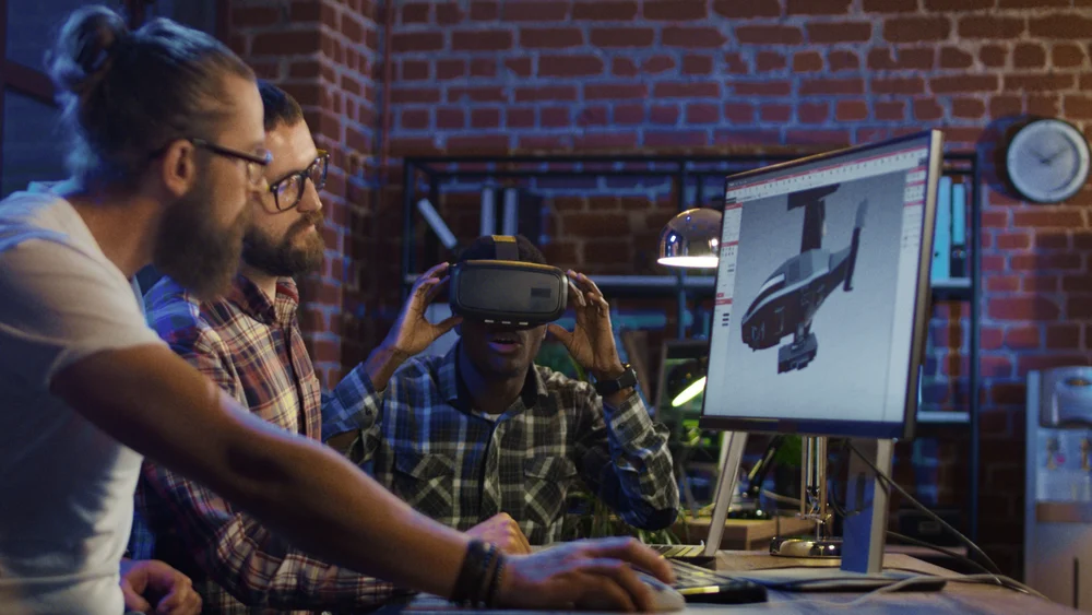 Three graphic designers working on a virtual reality project to showcase how is animation used in advertising.