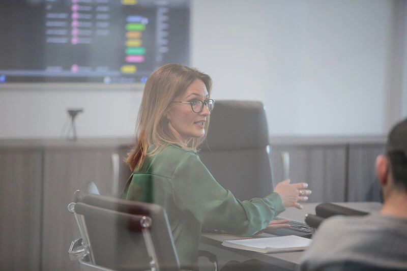 Castle Int. consultant presenting in the boardroom with a campaign dashboard on screen