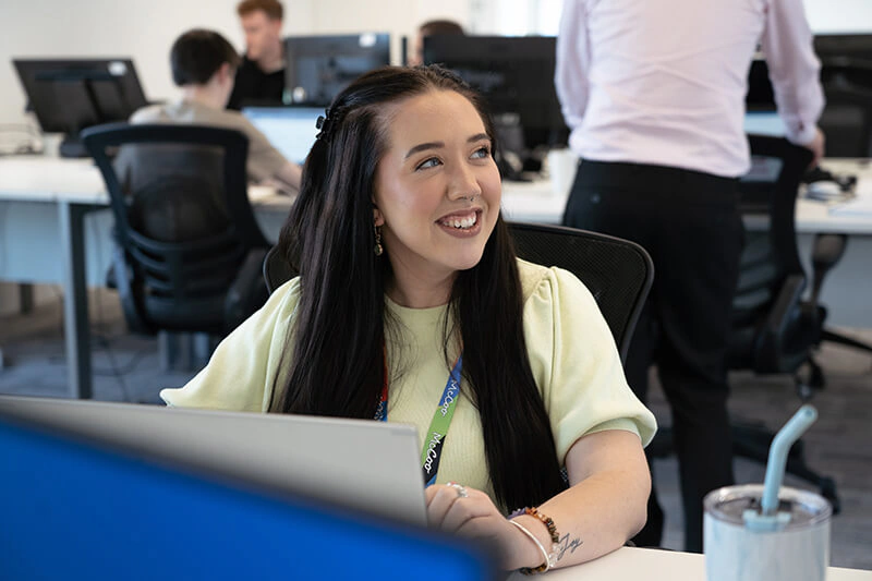 One of Castle Int.'s experts smiling at her desk in the office