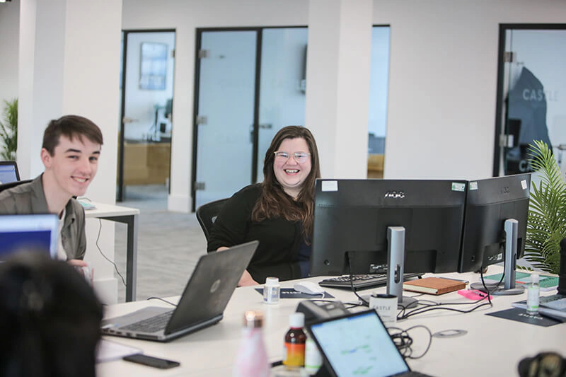Smiling Castle Int. consultants at their desks in the Liverpool office