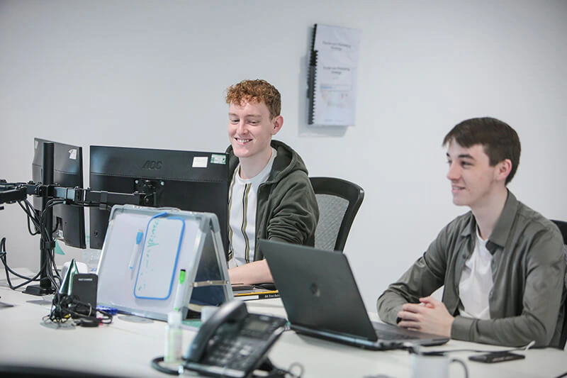Two consultants of Castle Int.'s Liverpool team working at their workstations