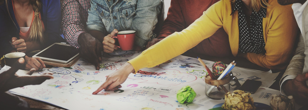 Marketing team brainstorming around a colourful hand-drawn social communication mind map