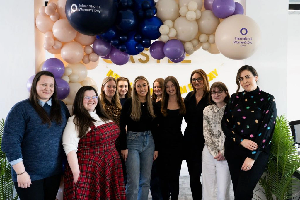 Women of Castle Int.'s Liverpool team celebrating International Women's Day 2022 beneath balloons in the office