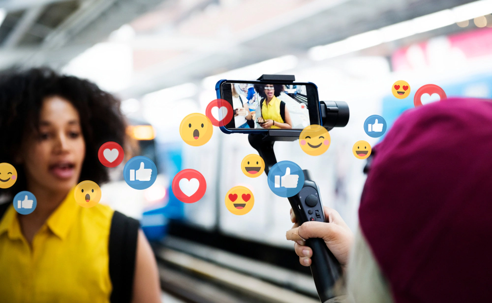 Influencer filmed on a smartphone gimbal surrounded by floating like and love reactions