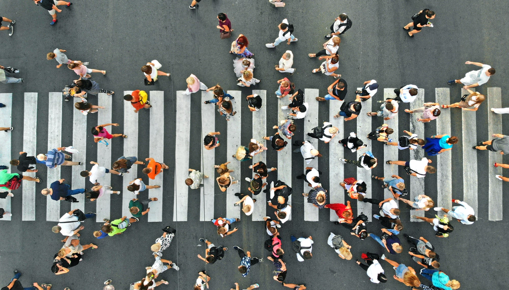 Aerial view of a crowd of pedestrians crossing a zebra crossing