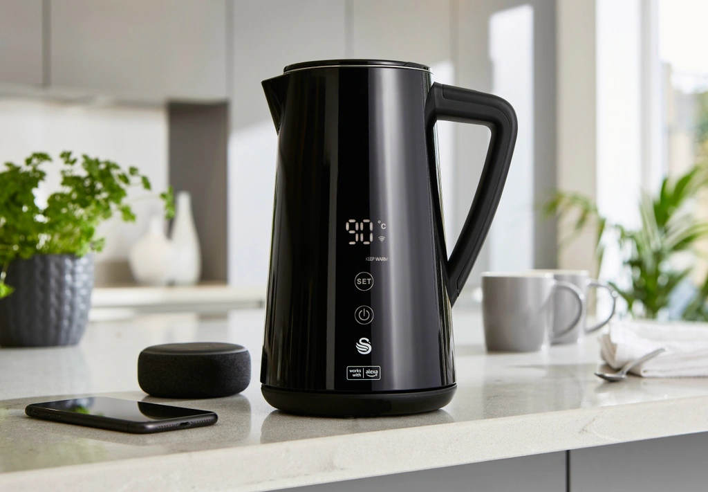 Swan Alexa smart kettle with digital display beside an Amazon Echo Dot on a kitchen worktop