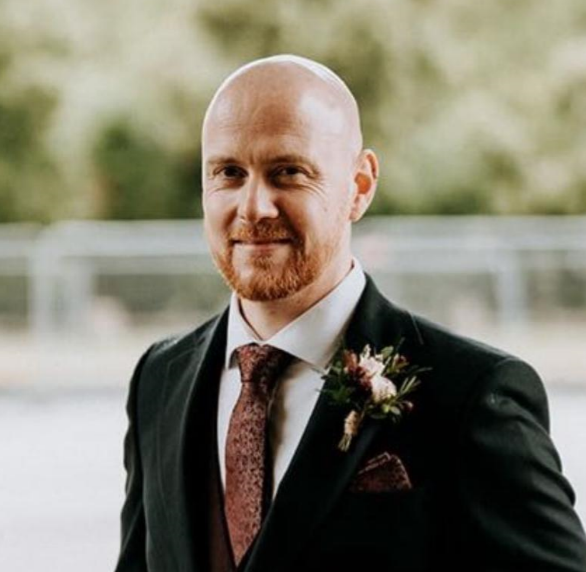 Smiling man in a dark suit, testimonial headshot for ecommerce client Chuug