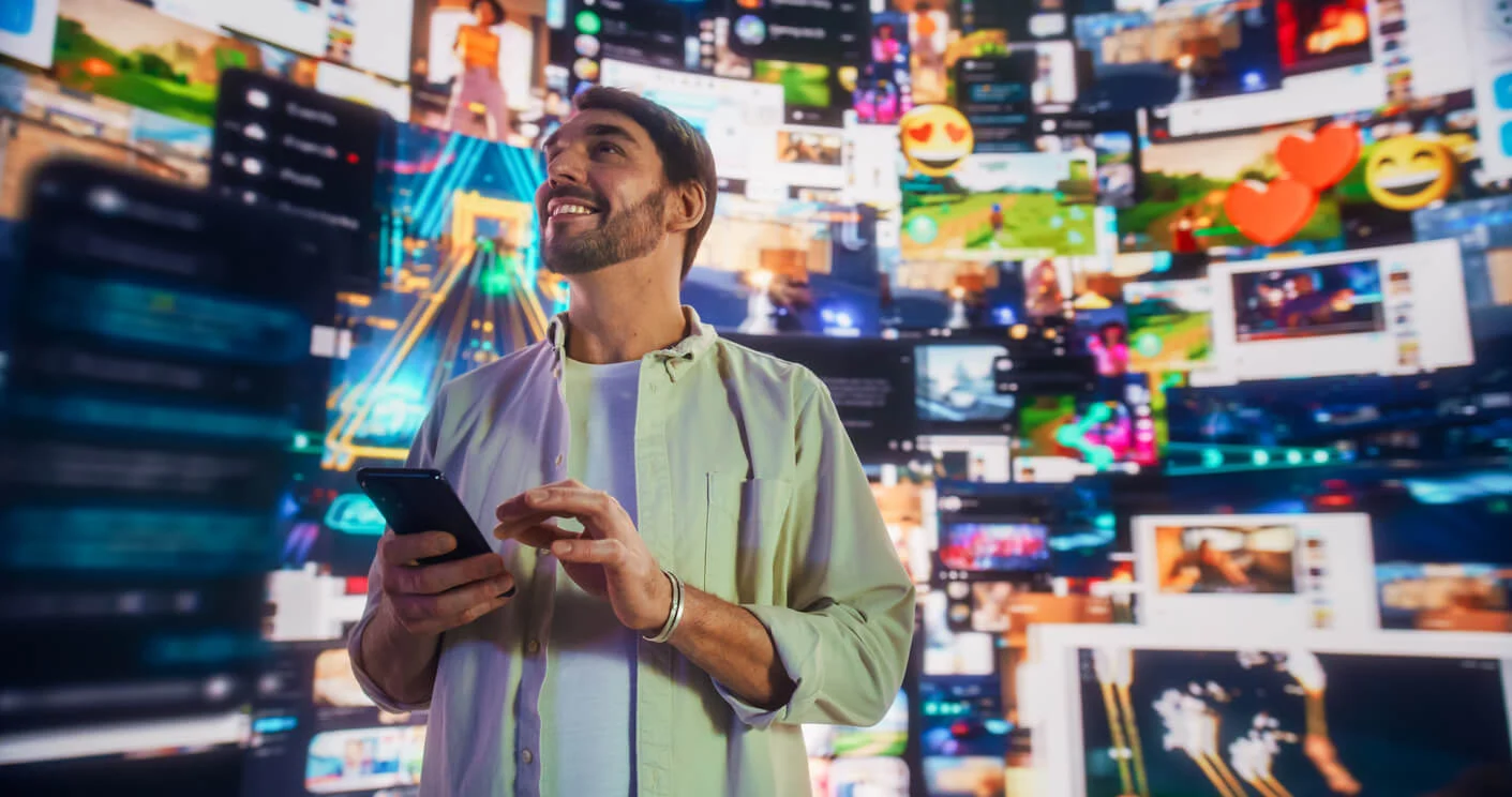 A man on a phone in a room surrounded by graphics of social media posts and sites.