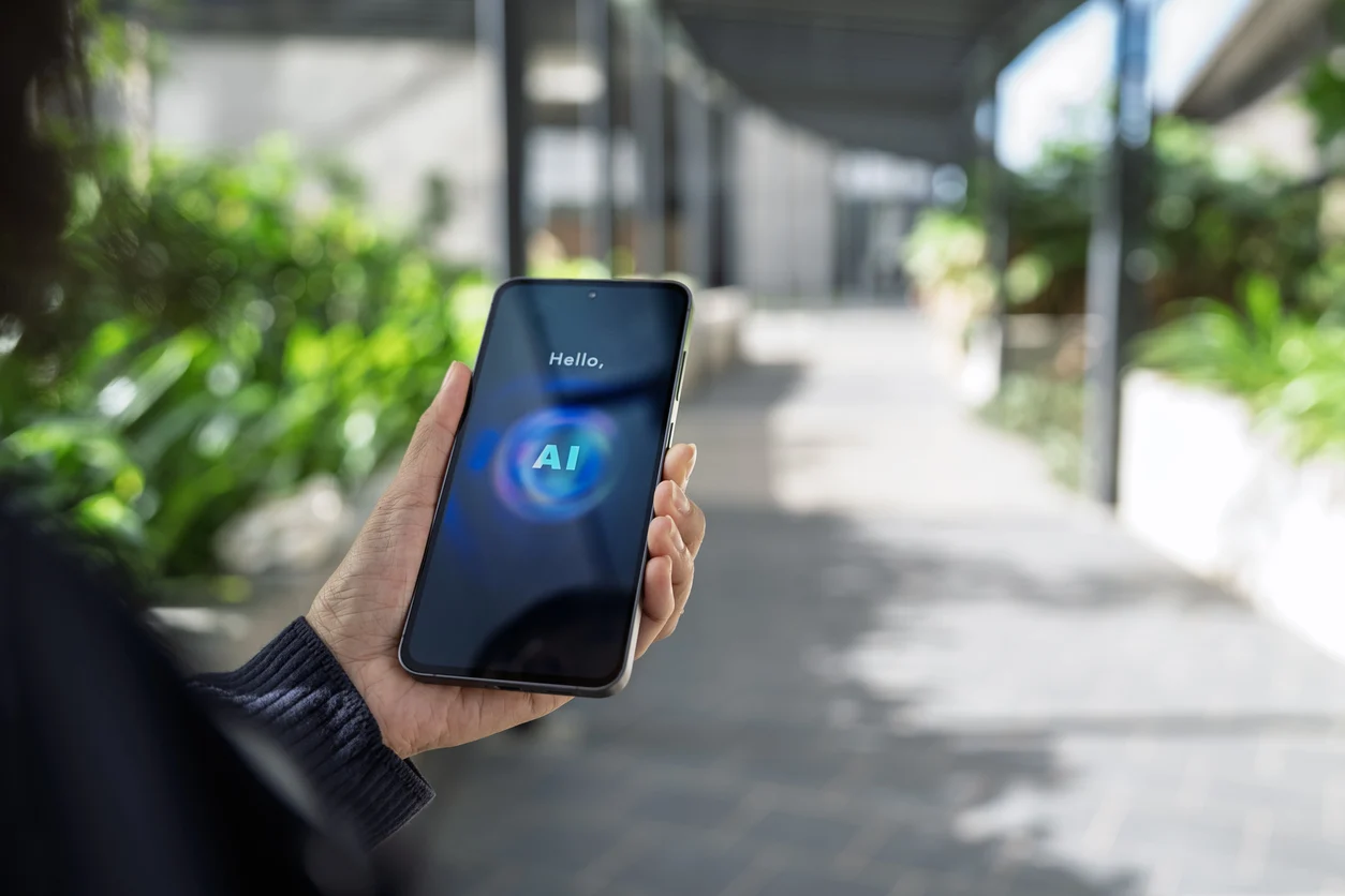 User accessing an AI assistant on a smartphone while outdoors, demonstrating mobile artificial intelligence technology for communication and productivity.